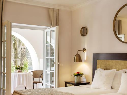 奥比多斯Casa Senhoras Rainhas - Óbidos - by Unlock Hotels的一间卧室配有一张床、一张桌子和一面镜子