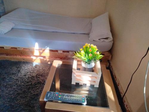 奈瓦沙M&M HOMES的小房间设有一张床和一张茶几及桌子