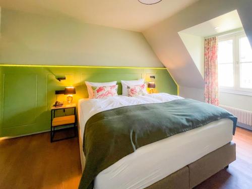 杜塞尔多夫Boutique Hotel Orangerie的一间卧室配有一张大床和绿色床头板