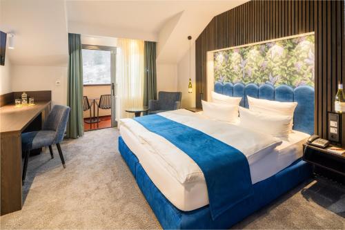 巴登-巴登海利根施泰酒店的酒店客房设有一张大床和一张书桌。