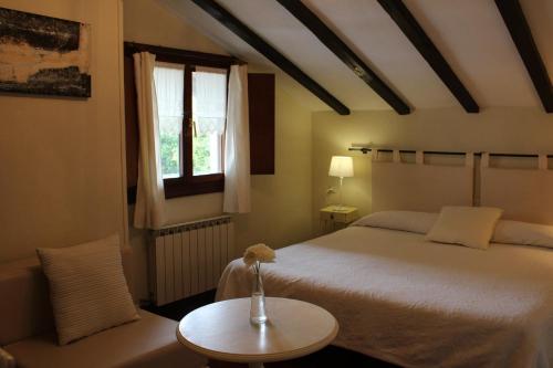 戈特赫斯阿特亚加Casa Rural Ozollo的一间卧室配有一张床、一张桌子和一个窗户。