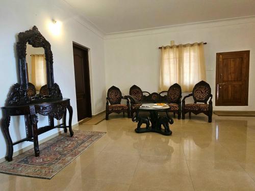 乌提Hestia Chalet 3BHK Villa的客厅配有椅子、桌子和镜子