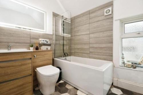 诺丁汉Spacious and homely House的带浴缸、卫生间和盥洗盆的浴室