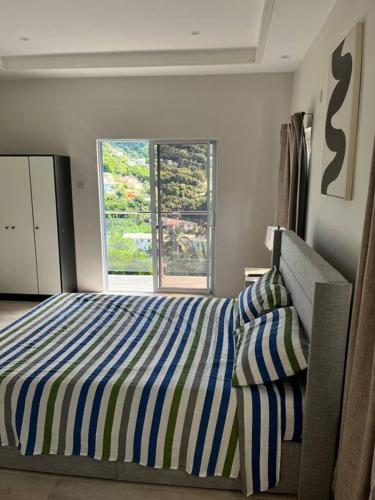 CorintheSolaris 2: Peaceful Condo close to Tourist Spots的一间卧室配有条纹床和窗户