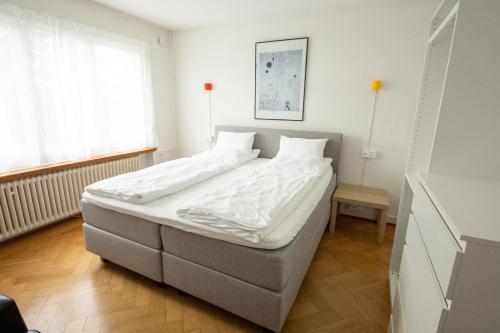 苏黎世Luegete 28, Witikon Apartments的一间卧室配有一张带白色床单的大床