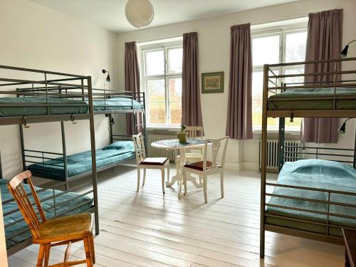兰斯克鲁纳STF Landskrona Hostel的客房设有四张双层床和一张桌子及椅子。