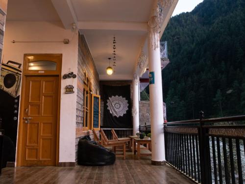 卡索尔Wabi Sabi Riverside Hostel的阳台设有木门和桌椅。