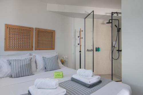 阿基欧斯尼古拉斯Beachfront Salty Sea Luxury Suite 2的一间卧室设有淋浴,另一张床设有2条毛巾