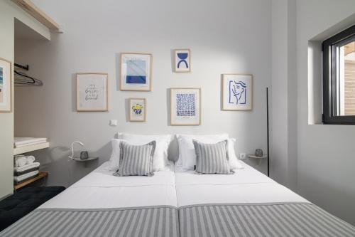 阿基欧斯尼古拉斯Beachfront Salty Sea Luxury Suite 2的墙上挂着照片的白色床