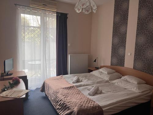 布达佩斯Hotel Rose City的一间卧室设有一张床和一个大窗户