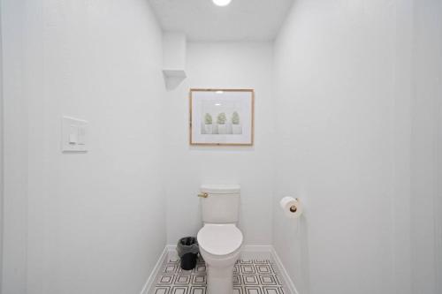 西班牙福克Spanish Fork Retreat的浴室设有白色卫生间,墙上挂着一幅画
