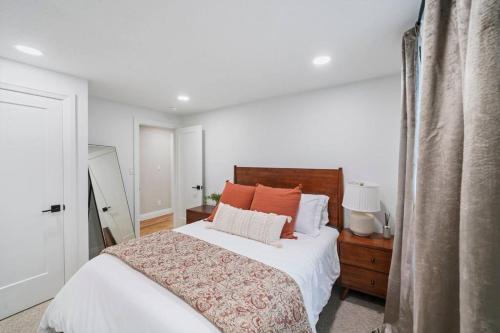 西班牙福克Spanish Fork Retreat的一间卧室配有带白色床单和橙色枕头的床。