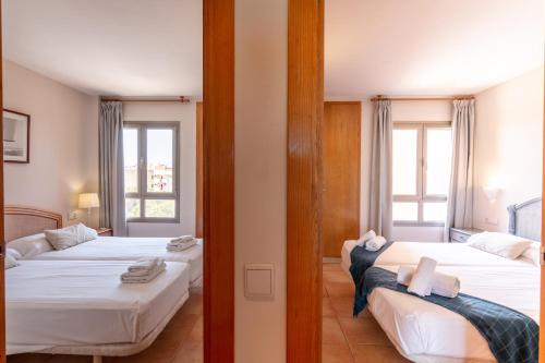 科洛尼亚圣霍尔迪Holiday beach homes Romaní II的带2扇窗户的客房内的2张床