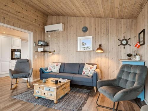 伦德Holiday Home Gyrid - 150m from the sea in Djursland and Mols by Interhome的客厅配有蓝色的沙发和两把椅子