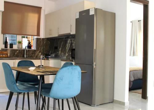 帕特雷Patras Cozy Nest in the Vibrant City Center的厨房配有桌子、蓝色椅子和冰箱
