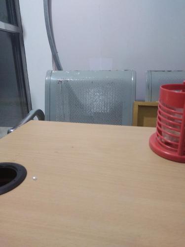 尼甘布SRI ROYAL Castle的坐在椅子旁边的桌子上的一个红杯