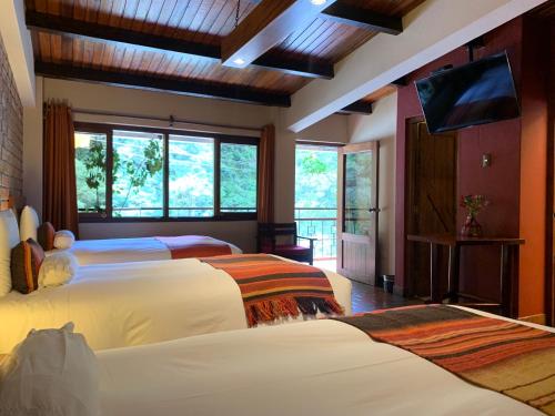 马丘比丘全景住宿加早餐酒店的一间卧室配有两张床和一台平面电视