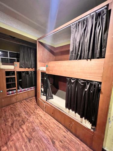 加德满都跋涉之家酒店的步入式衣柜,配有黑色窗帘和木地板