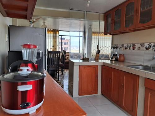 阿亚库乔Departamento de 3 pisos a 9 cuadras de la plaza的厨房在柜台上配有红色搅拌机