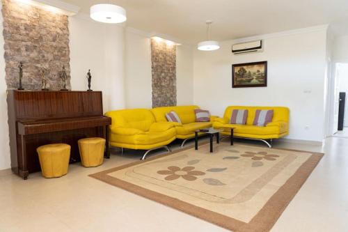 卡斯特利翁-德拉普拉纳Casa Moderna cerca de la PLAYA的客厅配有黄色家具和钢琴