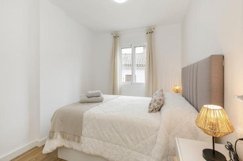 莫纳奇尔Apartamento Carmela的白色的卧室设有床和窗户