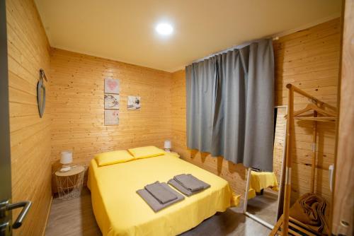 克洛伊奥斯Chalet d'Aroeira的一间卧室配有黄色的床和毛巾