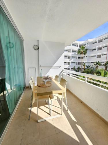 圣巴托洛梅Luxury Apartment Playa del Inglés的阳台的用餐室配有桌椅