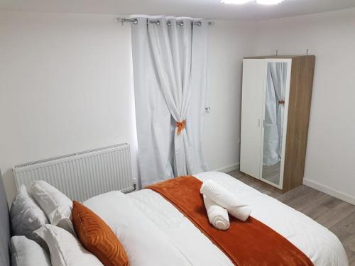 吉林汉姆Holiday Let - Entire modern home in Medway的一间卧室配有带枕头和镜子的床
