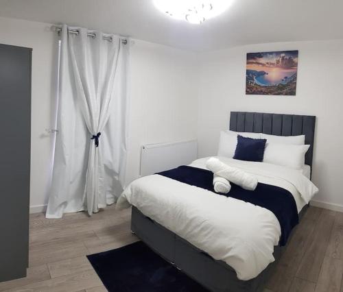吉林汉姆Holiday Let - Entire modern home in Medway的一间卧室配有一张带蓝白色枕头的大床