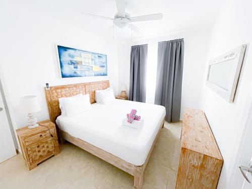 蓬塔卡纳CARIBBEAN GALAXY Paradise HOTEL Los Corales BAVARO BEACH CLUB & SPA的卧室配有一张白色的大床和一张桌子
