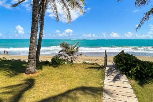 喀巴里特Villa Dance - Home with Steps to the Beach的通往棕榈树海滩和大海的木道