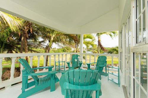 喀巴里特Villa Dance - Home with Steps to the Beach的一个带蓝色椅子和桌子的门廊