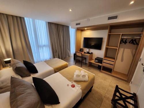 里奥夸尔托Amerian Rio Cuarto Apart & Suites的酒店客房设有两张床和电视。