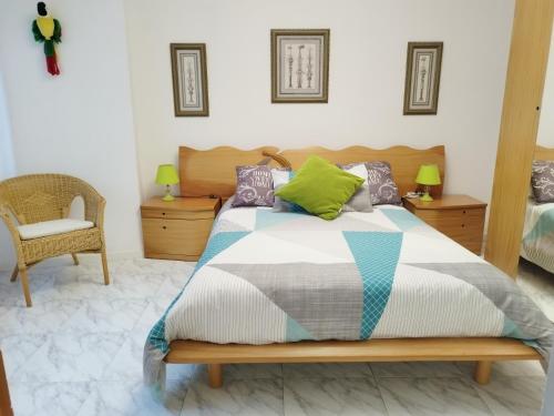 格罗韦Vistas Al Mar E Isla De La Toja的一间卧室配有一张床和一把椅子