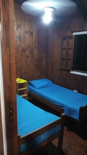 Puerto BossettiCabañas Aliwen的一间设有两张床和一张桌子的房间
