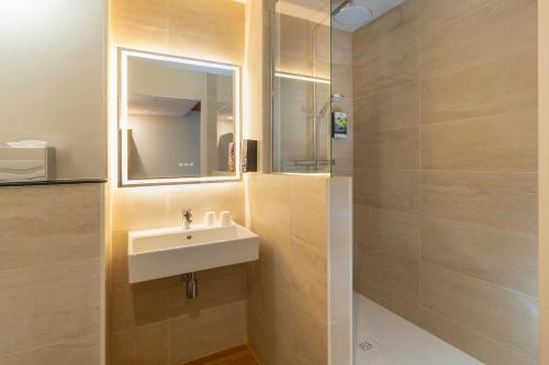 凯恩Sure Hotel by Best Western Caen Memorial的一间带水槽和镜子的浴室