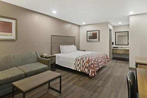 欧文Red Roof Inn & Suites Irving - DFW Airport South的酒店客房,配有床和沙发