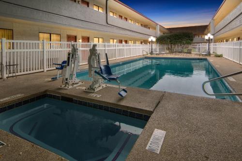 欧文Red Roof Inn & Suites Irving - DFW Airport South的大楼前的大型游泳池