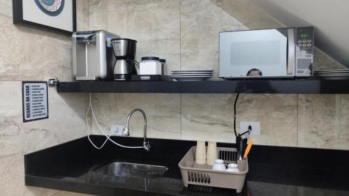 瓜鲁柳斯维多利亚旅馆的厨房配有水槽和微波炉