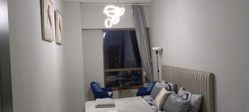 迪拜ocean view Dubai Marina JBR walk comfort room的一间卧室配有床、蓝色椅子和窗户