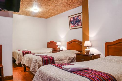 CarhuazLas Torrecitas的一间酒店客房,房间内设有三张床