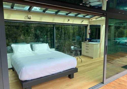 凯里凯里Mākoha PurePod的主卧室设有一张大床和一个阳台。