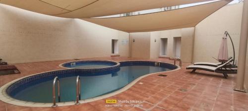 索哈尔SADARA HOTELS APARTMENTS的一座带天花板的大型游泳池