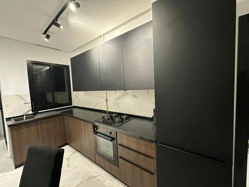 拉马萨Luxury appartement的厨房配有黑色橱柜和黑色冰箱。