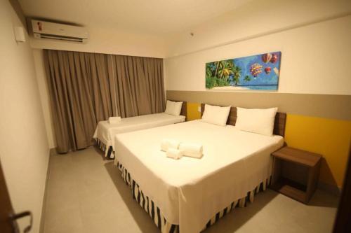 奥林匹亚Olimpia Park的酒店客房,配有两张带白色床单的床