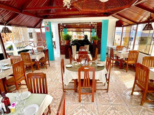 蓬塔内格拉Hostal Ocean Pacifico的餐厅内带桌椅的用餐室