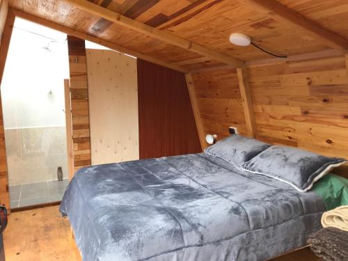 乔阿奇Hykata Wildcamp的木制客房内的一间卧室,配有一张床