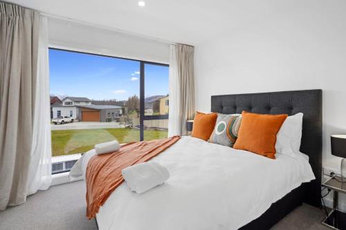 Albert TownWanaka Riverside serviced apartments by BCR Stays的一间卧室设有一张床和一个大窗户