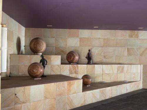 墨西哥城Hotel Max的石墙,上面有花瓶和雕塑