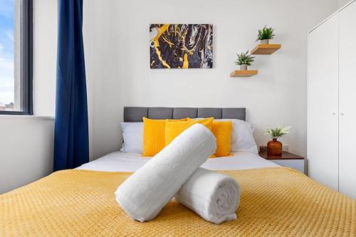 赫默尔亨普斯特德OCEAN BLUEZ 1bdr city centre的一间卧室配有一张黄色和白色的床
